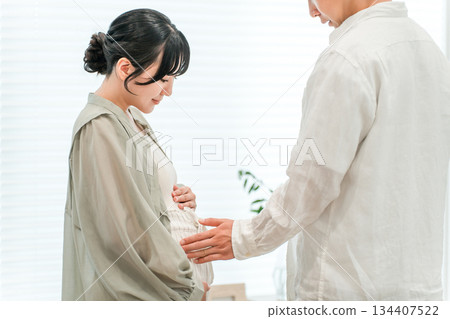 A couple in the living room of their home, a pregnant woman (maternity) A couple in the living room of their home, a pregnant woman (maternity) 134407522