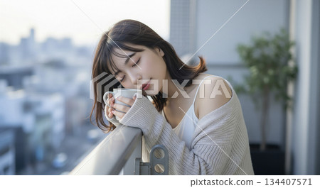 Woman drinking coffee on the balcony 134407571