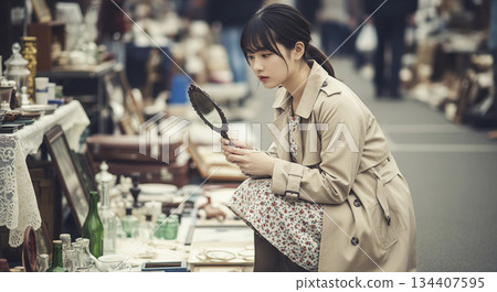 A woman enjoying antique hunting at a flea market 134407595