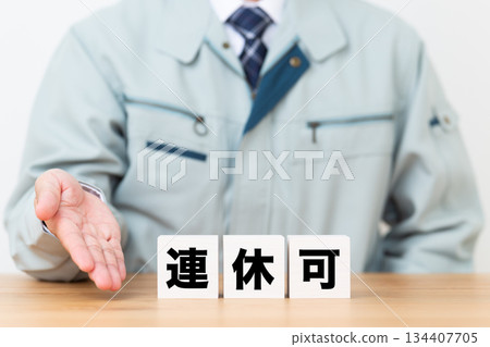 一塊標示著連續假期的方塊,以及一位身著工作服的中年男性商務人士 一塊標示著連續假期的方塊,以及一位身著工作服的中年男性商務人士 134407705