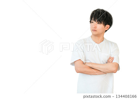 A young Asian man in a T-shirt thinking with his arms crossed (worried, worried, considering, troubled) A young Asian man in a T-shirt thinking with his arms crossed (worried, worried, considering, troubled) 134408166