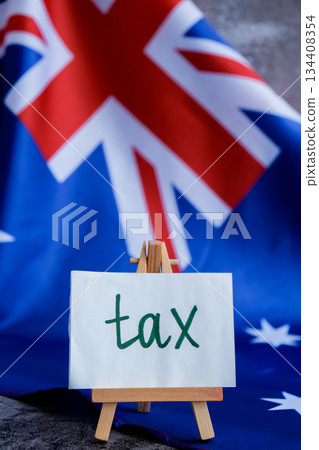 Message text TAX beside Australian flag for government or finance communication. National identity for tax awareness campaigns. Concept of revenue, legislation Message text TAX beside Australian flag for government or finance communication. National identity for tax awareness campaigns. Concept of revenue, legislation 134408354