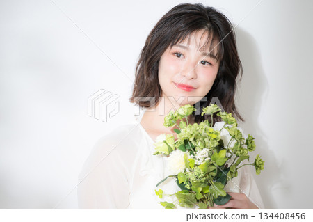 A natural smile and transparency of a young woman holding a bouquet on a white background. Images of pre-wedding photos, botanicals, etc. A natural smile and transparency of a young woman holding a bouquet on a white background. Images of pre-wedding photos, botanicals, etc. 134408456