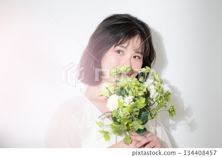 A natural smile and transparency of a young woman holding a bouquet on a white background. Full of happiness such as pre-wedding photoshoots and botanicals. A natural smile and transparency of a young woman holding a bouquet on a white background. Full of happiness such as pre-wedding photoshoots and botanicals. 134408457