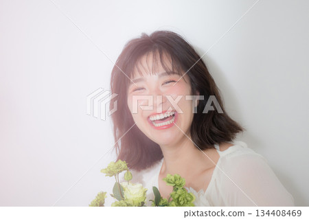 A natural smile and transparency of a young woman holding a bouquet on a white background. Full of happiness such as pre-wedding photoshoots and botanicals. A natural smile and transparency of a young woman holding a bouquet on a white background. Full of happiness such as pre-wedding photoshoots and botanicals. 134408469