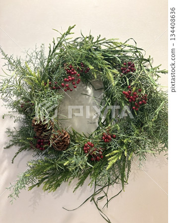 A natural Christmas wreath decorated on a white wall 134408636