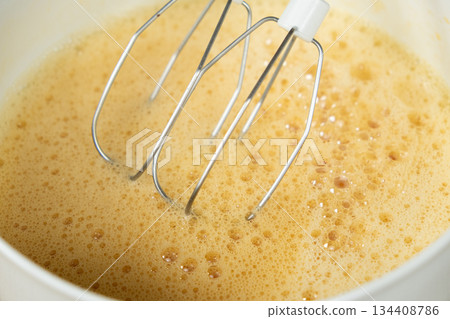 The process of beating eggs with sugar with a mixer, close-up, making the dough. The process of beating eggs with sugar with a mixer, close-up, making the dough. 134408786