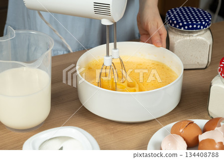 Close-up of the Baking Process. Preparing Dough with a Mixer on a Kitchen Countertop. 134408788