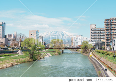 Beautiful Iwate mountain and Kitakami river with flowers blooming in Spring season, cityscape against blue sky in Morioka city, Iwate prefecture, Japan. Iwate, Japan, 24 April 2025 134408860