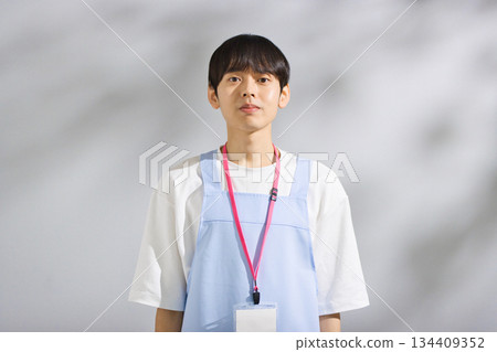 一位二十多歲的男幼教老師，穿著圍裙 134409352