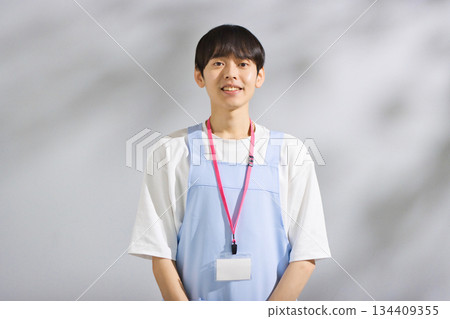 一位二十多歲的男幼教老師，穿著圍裙 134409355