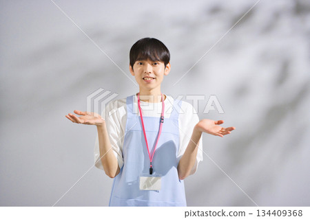 一位二十多歲的男幼教老師，穿著圍裙 134409368