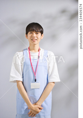 一位二十多歲的男幼教老師，穿著圍裙 134409374