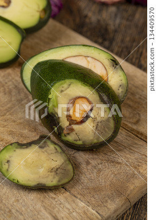 a green avocado with soft flesh cut into pieces long ago, the seed has changed color from the air 134409570