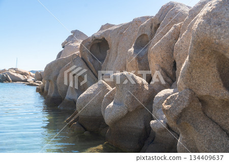 Smooth coastal rocks along calm clear sea water under blue sky. Natural seaside landscape, summer travel destination and peaceful outdoor atmosphere, Sardinian, La Maddalena, Italy Smooth coastal rocks along calm clear sea water under blue sky. Natural seaside landscape, summer travel destination and peaceful outdoor atmosphere, Sardinian, La Maddalena, Italy 134409637