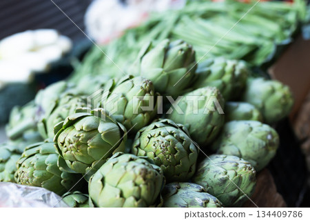 Pile of artichokes displayed on market counter 134409786