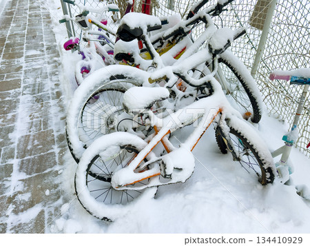 Snow covered bicycles in winter yard Snow covered bicycles in winter yard 134410929