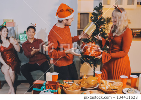 Festive Office Christmas Party with Delicious Food. A beautifully decorated office space with Christmas trees and festive lights, set up for a holiday party. 134411628