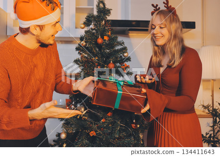 Festive Office Christmas Party with Delicious Food. A beautifully decorated office space with Christmas trees and festive lights, set up for a holiday party. 134411643