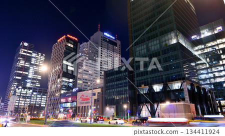 Warsaw, Poland. 4 November 2025. City life after dark. Dense corporate development in center city in the night. Lights street and buildings towering around them. Warsaw, Poland. 4 November 2025. City life after dark. Dense corporate development in center city in the night. Lights street and buildings towering around them. 134411924