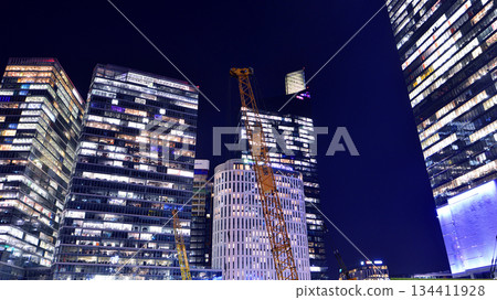Warsaw, Poland. 4 November 2025. City life after dark. Dense corporate development in center city in the night. Lights street and buildings towering around them. Warsaw, Poland. 4 November 2025. City life after dark. Dense corporate development in center city in the night. Lights street and buildings towering around them. 134411928