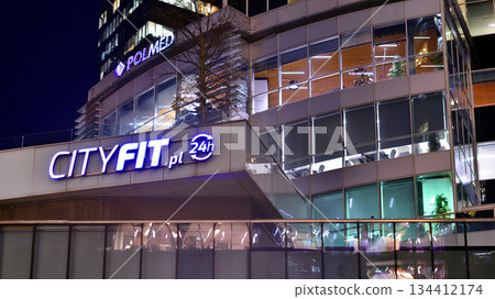 Warsaw, Poland. 4 November 2025. City life after dark. Company signboard "City Fit.pl". Dense corporate development in center city in the night. Lights street and buildings towering around them. 134412174