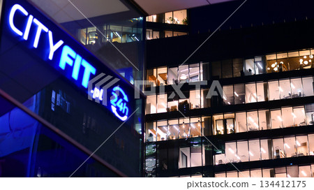 Warsaw, Poland. 4 November 2025. City life after dark. Company signboard "City Fit.pl". Dense corporate development in center city in the night. Lights street and buildings towering around them. 134412175