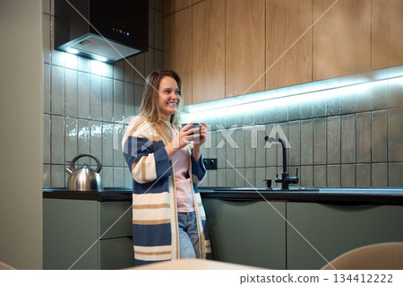 Freelancer evening routine with warm drink in modern kitchen Freelancer evening routine with warm drink in modern kitchen 134412222