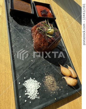 beef filet mignon Filet mignon steaks with cherry tomatoes on a black mica plate. Close-up. High quality photo 134412381