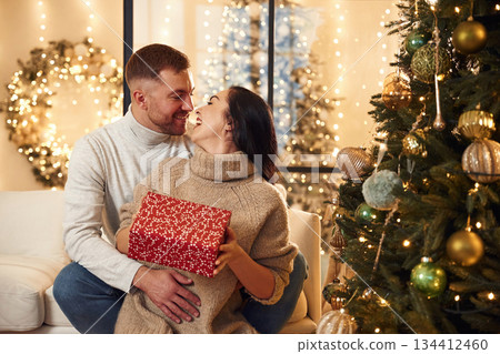 Gift for a woman. Couple is celebrating new year indoors together 134412460