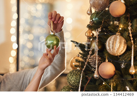 Close up view of man's and woman's hands that are holding New Year decoration for the tree Close up view of man's and woman's hands that are holding New Year decoration for the tree 134412469