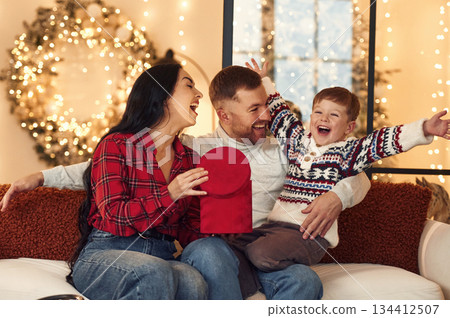 Happy boy is with gift. Family celebrating new year together at home 134412507