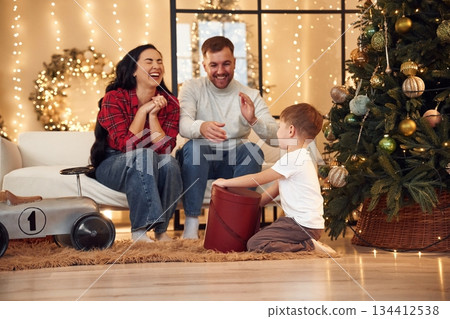 Surprise, present for a boy. Happy family celebrating new year together at home 134412538