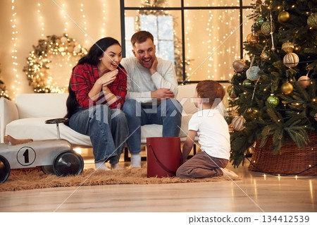 Surprise, present for a boy. Happy family celebrating new year together at home 134412539