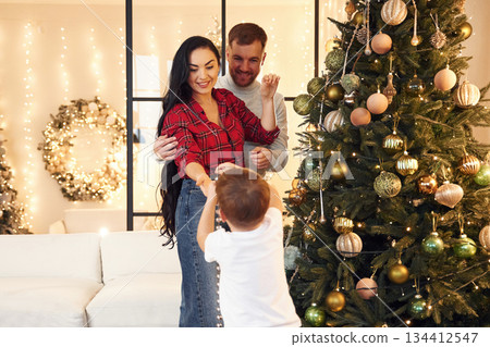 Well decorated tree. Happy family celebrating new year together at home 134412547
