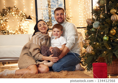 On the floor, sitting. Happy family celebrating new year together at home On the floor, sitting. Happy family celebrating new year together at home 134412568