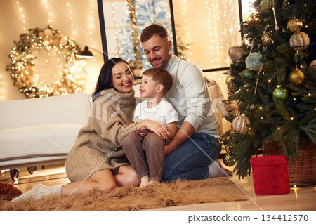 On the floor, sitting. Happy family celebrating new year together at home On the floor, sitting. Happy family celebrating new year together at home 134412570