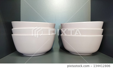 Stacked white ceramic bowls on shelf Stacked white ceramic bowls on shelf 134412806