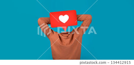 A person sits back with arms behind their head, appearing relaxed. Above them is a prominent red speech bubble with a white heart icon, showcasing a connection to social media. A person sits back with arms behind their head, appearing relaxed. Above them is a prominent red speech bubble with a white heart icon, showcasing a connection to social media. 134412915