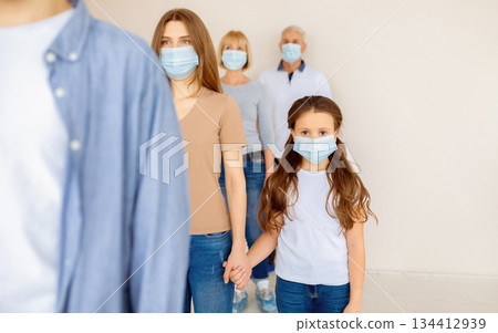 Parent and child in medical masks waiting in line for coronavirus vaccination at clinic. Covid-19 immunization, prevention of worldwide infectious disease outbreak concept Parent and child in medical masks waiting in line for coronavirus vaccination at clinic. Covid-19 immunization, prevention of worldwide infectious disease outbreak concept 134412939
