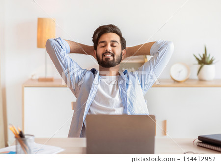 Smiling Arab Freelancer Guy Leaning In Chair, Relaxing At Workplace After Working Remotely On Laptop In Home Office, Happy Successful Eastern Man Enjoying Distant Job Opportunities, Free Space Smiling Arab Freelancer Guy Leaning In Chair, Relaxing At Workplace After Working Remotely On Laptop In Home Office, Happy Successful Eastern Man Enjoying Distant Job Opportunities, Free Space 134412952