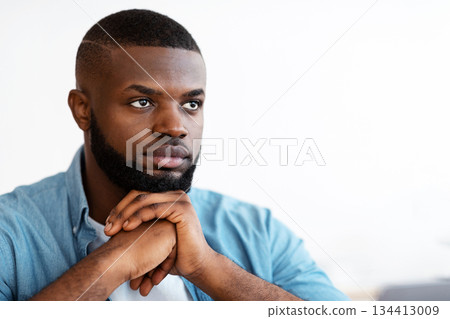 Closeup Portrait Of Serious Handsome Black Man Sitting With Pensive Face Expression, Young African American Guy Thinking About Something, Waiting For Inspiration, Leaning Chin On Hands, Copy Space Closeup Portrait Of Serious Handsome Black Man Sitting With Pensive Face Expression, Young African American Guy Thinking About Something, Waiting For Inspiration, Leaning Chin On Hands, Copy Space 134413009