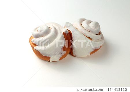 Fragrant Cinnabons with cream on a white background. Insulation 134413110