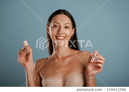 Professional skin care. Young woman is in the studio against background Professional skin care. Young woman is in the studio against background 134413366
