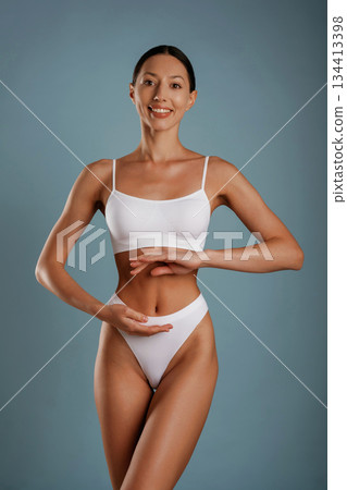 Diet conception. Young woman is in the studio against background Diet conception. Young woman is in the studio against background 134413398
