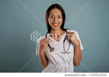 Medical worker, nurse is standing. Young woman is in the studio against background Medical worker, nurse is standing. Young woman is in the studio against background 134413559