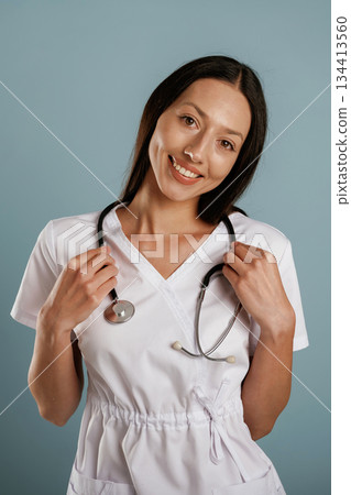 Medical worker, nurse is standing. Young woman is in the studio against background 134413560
