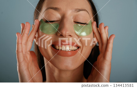 Pretty young woman is in the studio against background 134413581