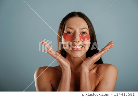 Time for beauty procedures, red patches under eyes. Young woman is in the studio against background Time for beauty procedures, red patches under eyes. Young woman is in the studio against background 134413591