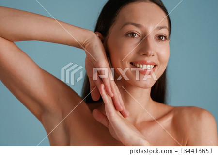 Smooth clean skin, posing. Young woman is in the studio against background Smooth clean skin, posing. Young woman is in the studio against background 134413651